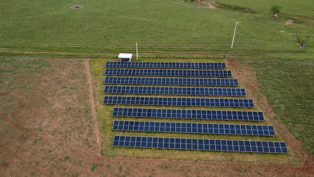 Linus photovoltaic plant seen from above: eight rows of modules in a fenced area of pasture.