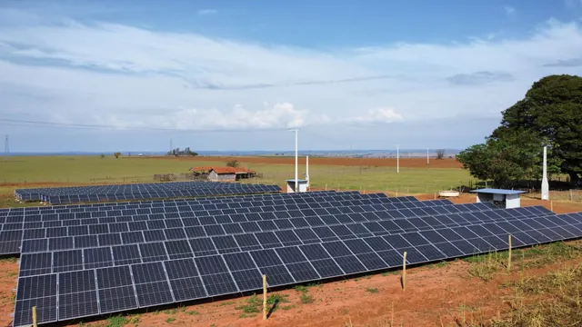 Linus photovoltaic plant on red soil, with an inverter shelter and a barn in the background.